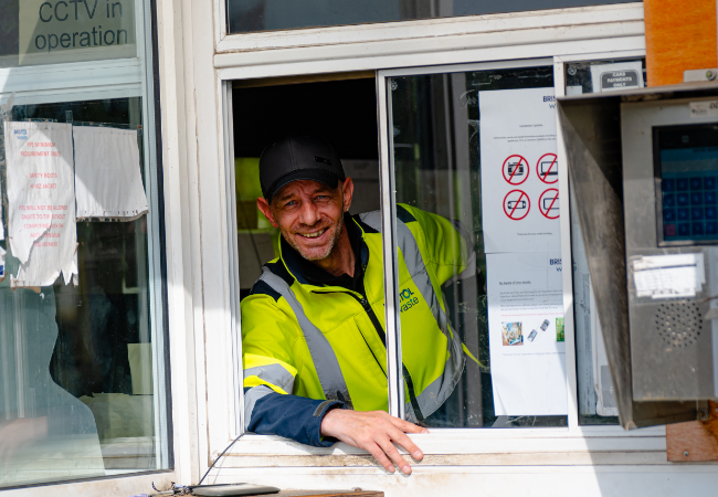 Man in hi-vis clothing inside a booth smiling