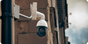 CCTV camera on a brick wall behind