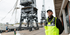 Security guard in high visibility clothing on river dock