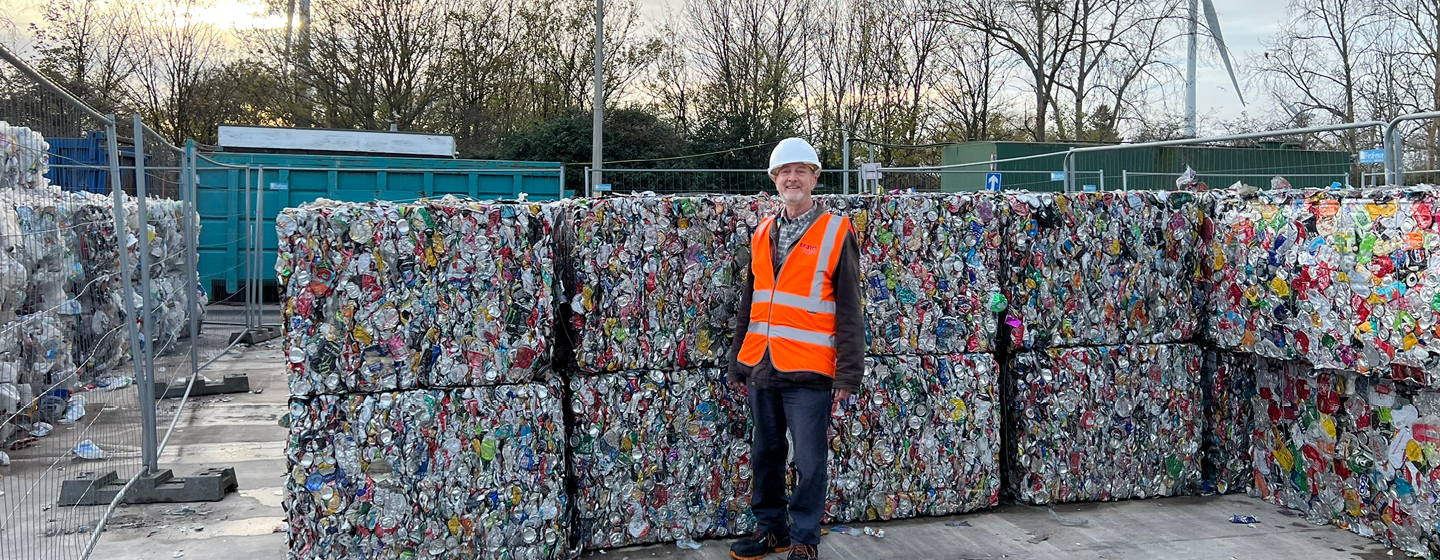 Councillor Martin Fodor stands in front of bales of plastic, ready to be recycled