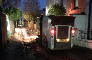 A mechanical sweeper clearing leaves in a Bristol side road